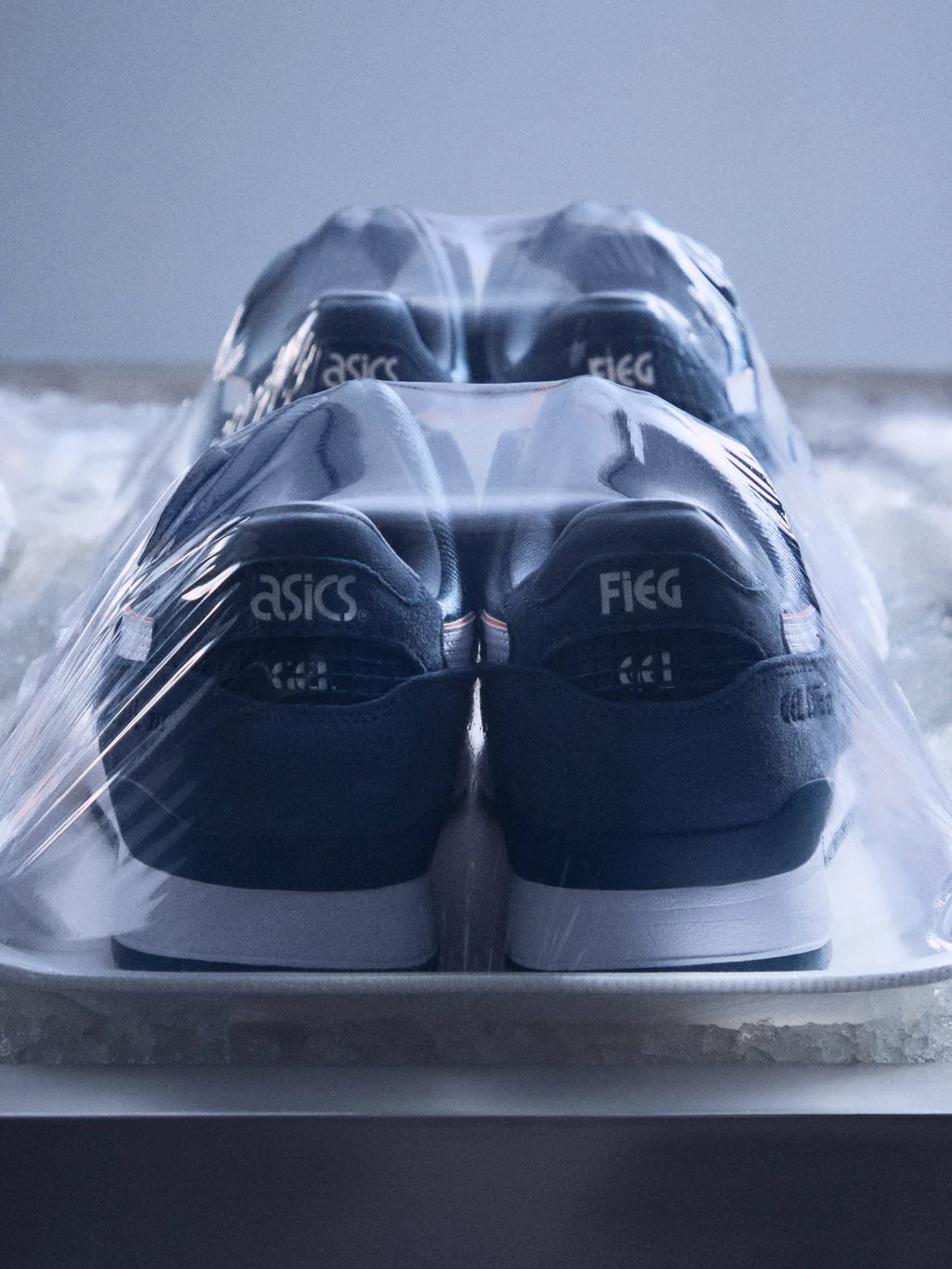 Kith × ASICS Salmon Toeを後方から撮影した公式写真。左右のヒールにASICSとFIEGのロゴ