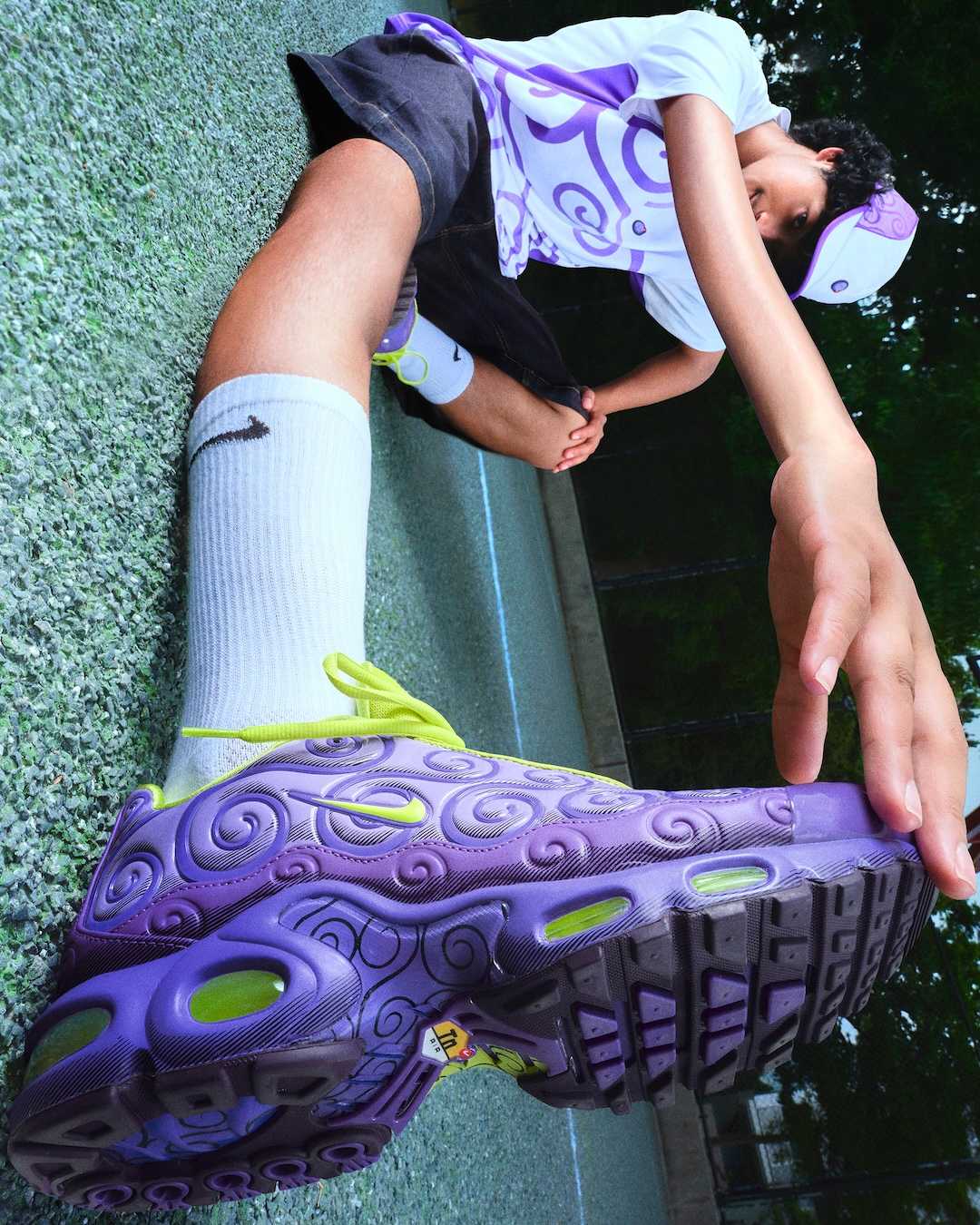 紫のゴムゴムの実エア マックス プラスと渦巻き模様のジャージー、キャップを着用したNike公式写真