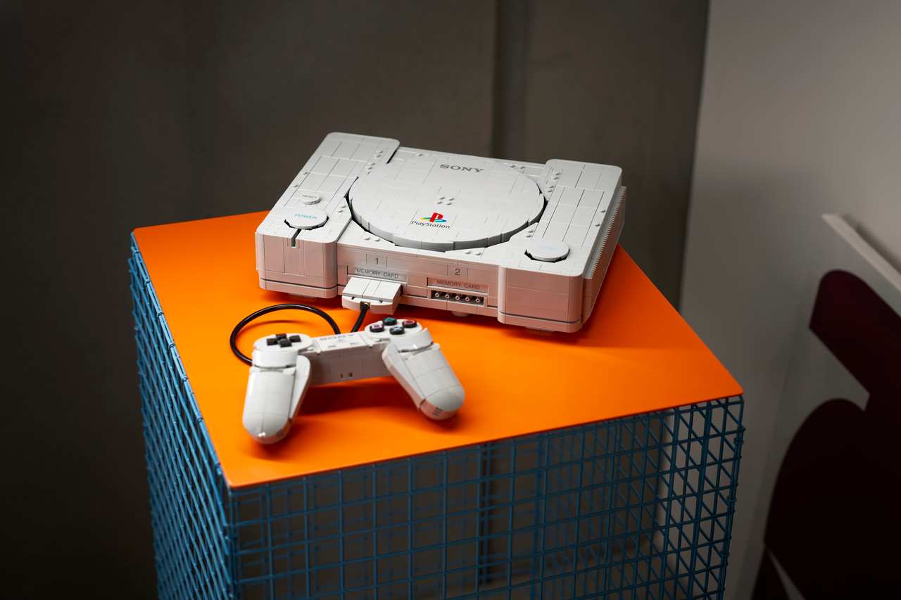 レゴで再現した初代PlayStation本体とコントローラーをオレンジの台に飾った写真